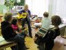 Učiteljica Maja in učenka Maruša igrata na kitaro, Neja na harmoniko.